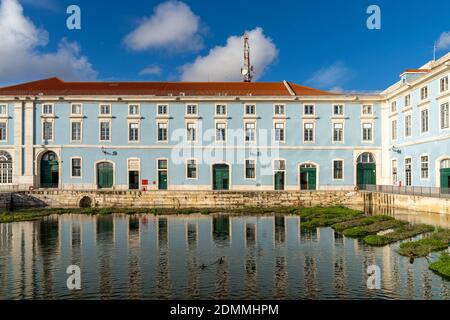 Lisbonne, Portugal - 15 décembre 2020 : bâtiment aux murs bleus et blancs et aux portes vertes, qui se reflète dans un étang calme au premier plan Banque D'Images