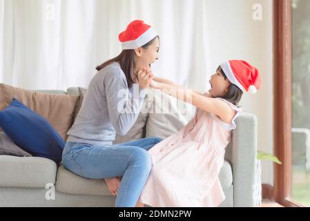 La fille asiatique de mère aime célébrer Noël et le nouvel an Fête à la maison en décembre Banque D'Images