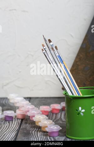 Peindre par numéro les pinceaux et les peintures. À proximité se trouve un fragment d'une image peinte. Sur les planches de pin noir. Banque D'Images