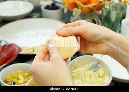 Femme cuisant des boulettes savoureuses, gros plan. petits boulettes maison avec différentes garnitures. Boulettes de pommes de terre Banque D'Images