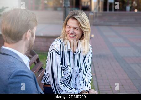 Belle femme d'affaires mûre riant, parlant à son collègue à l'extérieur dans la ville d'affaires, l'espace de copie. Communication, concept de réussite Banque D'Images