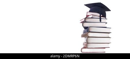 graduation cap on a hight stack of books isolated on white background Stock Photo