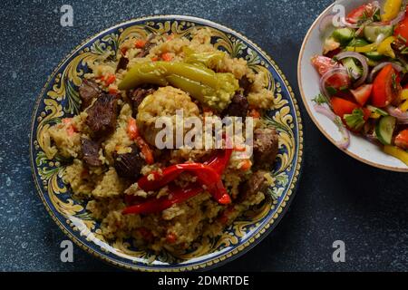 Cuisine ouzbek (nourriture) pilaf (plov), salade achichuk (achuchuk).mouton, riz, carottes, huile végétale, raisins secs, oignon, curcuma, poivre noir, cumin Banque D'Images