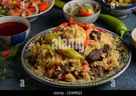 Cuisine ouzbek (nourriture) pilaf (plov), salade achichuk (achuchuk).mouton, riz, carottes, huile végétale, raisins secs, oignon, curcuma, poivre noir, cumin Banque D'Images