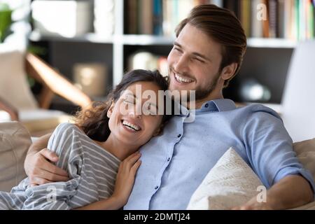 Un jeune couple heureux se détendre sur un canapé Banque D'Images