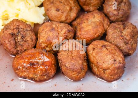 boulettes de viande suédoises cuites à la sauce aux baies de lingonis et purée de pommes de terre gros plan sur la plaque bleue Banque D'Images