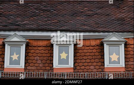 Seligenstadt, Allemagne. 17 décembre 2020. Des poinsettias sont accrochés dans les puits de lumière d'une ancienne maison à colombages de la vieille ville. Dans la lutte contre le virus corona, la vie publique est fermée pour la deuxième fois cette année. Credit: Arne Dedert/dpa/Alay Live News Banque D'Images