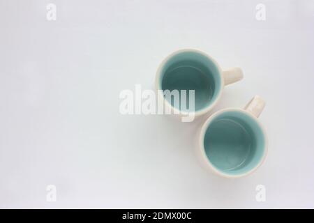 Deux tasses à café expresso blanc vides bleues à l'intérieur sur une table blanche. Vue de dessus. Copier l'espace Banque D'Images