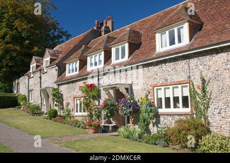 East Dean, East Sussex, Angleterre. Rangée de cottages typiques donnant sur le village vert. Banque D'Images