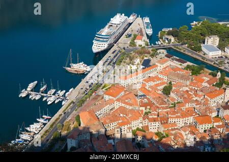 Kotor, Monténégro. Vue sur les toits carrelés de la vieille ville depuis les murs de la ville, le bateau de croisière Azamara Journey dans le port. Banque D'Images