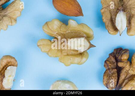 Noix, noix, amandes et noisettes sur fond bleu, image macro Banque D'Images