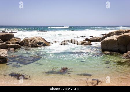 L'eau claire de Cristal sur la plage rocheuse le jour ensoleillé à Maitencillo, au Chili. Mer agitée avec vagues sauvages sur la côte du Pacifique. Été, paysage naturel Banque D'Images