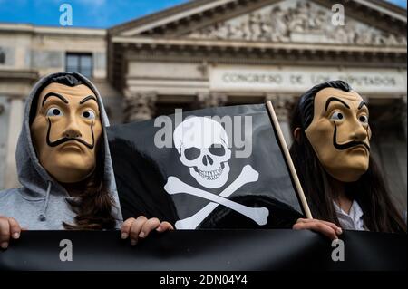 Madrid, Espagne. 17 décembre 2020. Les manifestants portant un masque facial de Dali portant un drapeau avec des crânes lors d'une manifestation contre l'euthanasie devant le Parlement espagnol, car on s'attend à ce qu'une loi réglementant l'euthanasie soit approuvée aujourd'hui. La manifestation a été soutenue par l'Association catholique des avocats et le parti d'extrême-droite VOX. Credit: Marcos del Mazo/Alay Live News Banque D'Images