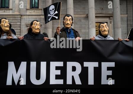 Madrid, Espagne. 17 décembre 2020. Les manifestants portant un masque facial de Dali portant un drapeau au crâne lors d'une manifestation contre l'euthanasie devant le Parlement espagnol, car on s'attend à ce qu'une loi réglementant l'euthanasie soit approuvée aujourd'hui. La manifestation a été soutenue par l'Association catholique des avocats et le parti d'extrême-droite VOX. Credit: Marcos del Mazo/Alay Live News Banque D'Images