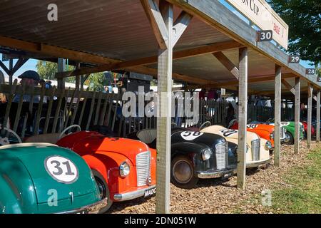 Les voitures à pédales utilisées dans le sprint pour enfants attendent dans les fosses au soleil au Goodwood Revival 2019. Banque D'Images