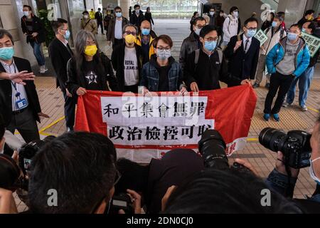 Activistes pro-démocratie (G-D) ancien législateur Leung Kwok-Hung, également connu sous le nom de long Hair, figo Chan, le coordinateur des droits de l'homme civils, et Eddie Chu, ancien législateur, ont tenu une bannière avant l'audience.des militants pro-démocratie arrivent au tribunal des magistrats de West Kowloon pour avoir été accusés de l'assemblée illégale dans le cadre d'une manifestation le 1er juillet 2020. Banque D'Images