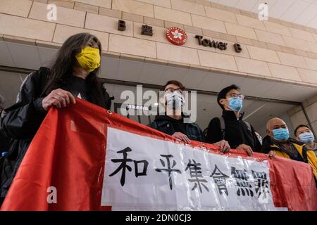 Pro-democracy activists (L-R) Former lawmaker Leung Kwok-hung, also known as Long Hair, convener of civil human rights front Figo Chan, former lawmaker Eddie Chu and district councillor Tsang Kin-shing holding a banner ahead of the court hearing.Pro-democracy activists arrive at the West Kowloon Magistrates' Court for charges of the illegal assembly in connection with a protest on 1st July 2020. Stock Photo