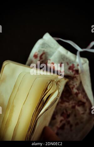 A selective focus vertical shot of a bloody face mask and a blank old book pages - the horror concept Stock Photo