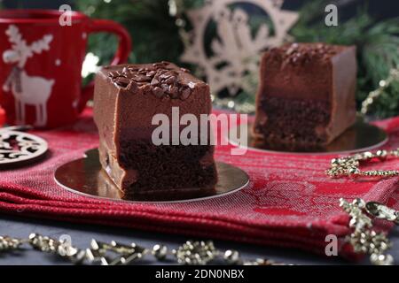 Brownie au chocolat avec confit à la framboise et mousse au café recouvert de glaçage au chocolat gastronomique sur fond de nouvel an. Banque D'Images