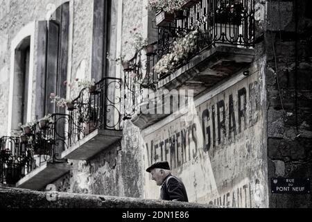 Le vieux Français dans un beret marchant a passé une publicité peinte d'époque, Limoux. Languedoc. Sud de la France. Europe Banque D'Images