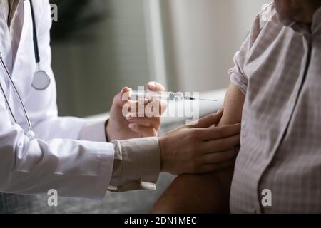 Les mains du travailleur médical injectent la dose de médicament dans le bras du patient Banque D'Images