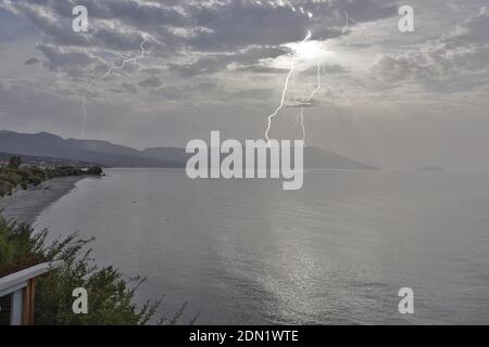 Orage matinal au-dessus de la baie de Votsalakia sur l'île grecque de Samos pendant le lever du soleil. Banque D'Images