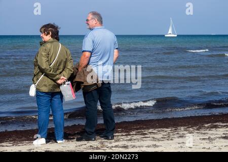 Couple senior debout sur la plage de la mer Baltique à Warnemunde en automne Banque D'Images