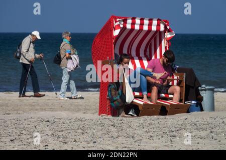 Un jeune couple dans une chaise de plage et un couple senior marchant sur une plage Allemagne mer Baltique, un jeune couple vieux Allemagne Warnemunde Banque D'Images