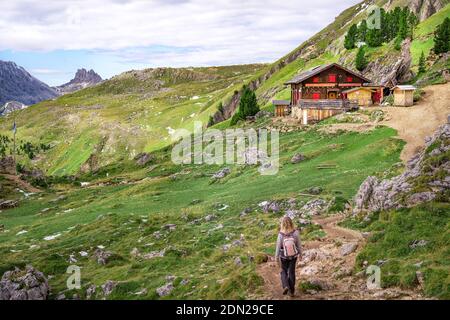 une femme qui se promette dans une maison en bois dans les dolomites autrichiens Banque D'Images