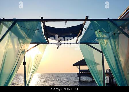 Tente romantique sur la plage contre un magnifique coucher de soleil Banque D'Images