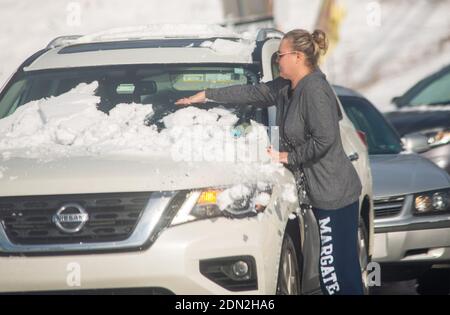 Une femme non identifiée (PHOTOGRAPHIÉE À TRAVERS LE PARE-BRISE D'UNE VOITURE) arrête la circulation sur Holland Rd. Alors qu'elle enlève la neige de son pare-brise après une tempête de neige d'hiver a jeté 8 pouces de substance jeudi, 17 décembre 2020 à Churchville, Pennsylvanie. La tempête de neige a provoqué la fermeture des écoles et paralysé certaines parties de la région de Philadelphie. Crédit : William Thomas Cain/Alay Live News Banque D'Images