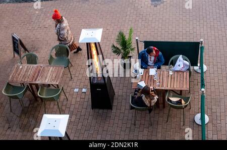 Brighton UK 17th December 2020 - Customers enjoy a drink and meal at a Brighton seafront restaurant at the end of a bright day on the South Coast . The city of Brighton and Hove has been kept in coronavirus Tier Two restrictions in England after an announcement  earlier today by the Health Secretary Matt Hancock : Credit Simon Dack / Alamy Live News Stock Photo