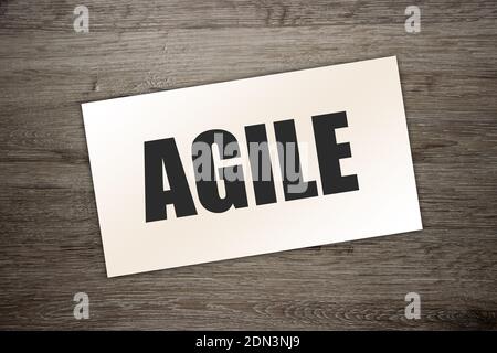 Carte de visite papier avec texte AGILE , gros plan sur fond en bois. Concept d'entreprise Banque D'Images