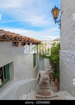 Vue sur la mer urbaine. En descendant les escaliers étroits entre les murs blanchis à la chaux d'un village des Cyclades à Athènes, en Grèce. Banque D'Images