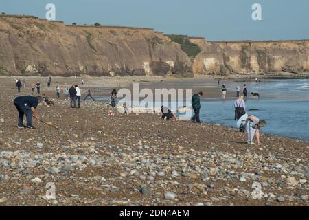 Vue sur la plage de Seaham avec des personnes à la recherche de morceaux de verre de mer qui peuvent être utilisés pour les ornements, bijoux de fantaisie et l'artisanat Banque D'Images