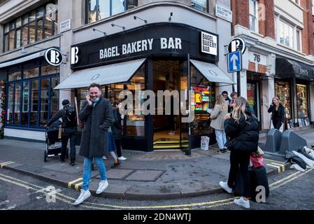 Londres, Royaume-Uni. 17 décembre 2020. Les gens à l'extérieur d'une boulangerie de bagel à Soho comme la capitale subit Tier 3, très haut niveau d'alerte, des restrictions tandis que la pandémie de coronavirus continue. En vertu du niveau 3, les aliments ne peuvent être servis qu'à titre de plats à emporter. Credit: Stephen Chung / Alamy Live News Banque D'Images