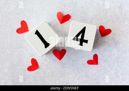 14 février. Calendrier en bois blanc avec coeurs rouges sur le dessus maquette de carte de Saint-Valentin. Pose à plat. Banque D'Images