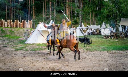 Cedynia, Poland June 2019 Historical reenactment of Battle of Cedynia, duel or sword fight, between two knights on horses in front of the wooden fort Stock Photo