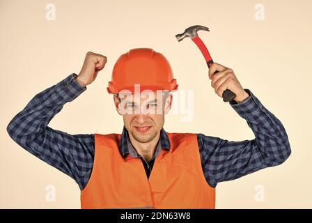 équipement de réparation d'outils de construction. jeune ouvrier est assistant d'ingénieur. réparateur en uniforme. homme travaille avec un marteau. vrai ouvrier de construction en casque. charpentier prêt à travailler. Banque D'Images