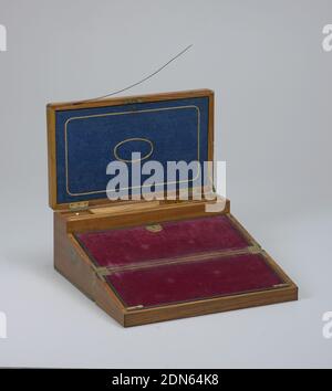 Bureau, cèdre (?), laiton, soie, velours, coton imprimé, papier de doublure à imprimé en bloc, verre, tresse en or métallique, boîte rectangulaire avec bords arrondis en laiton incrustés, bandes et ornements foliaires, serrure et poignées à chaque extrémité, encastré ajusté : couvercle à charnière dans lequel est monté une chemise en accordéon, carton recouvert de papier beige et blanc, coton avec motif oiseau exotique. Face intérieure du couvercle recouverte de soie tissée bleu vif avec bordure et ovale central de tresse en or métallique. Le fond de la boîte est doté de compartiments adaptés pour l'équipement d'écriture et d'un système d'écriture à charnière à l'avant Banque D'Images