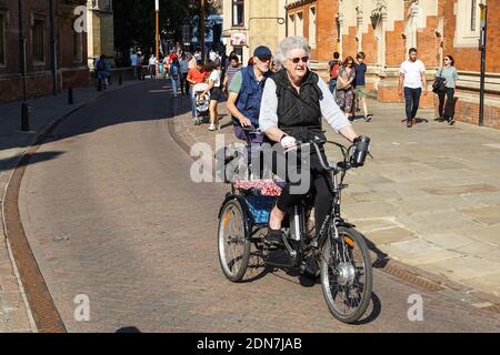 Ancienne femme à la retraite à bord d'un tricycle à Cambridge, Cambridgeshire Angleterre Royaume-Uni Banque D'Images