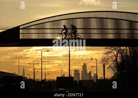 Des gens qui pédalent sur une passerelle au coucher du soleil à Londres, Angleterre, Royaume-Uni, Royaume-Uni Banque D'Images