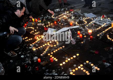 Les gens allument des bougies lors d'un rassemblement sur la place de la République (place de la République) à Paris le 8 janvier 2015, Le deuxième jour d'un hommage aux douze personnes tuées la veille dans une attaque de deux hommes armés sur les bureaux du journal satirique français Charlie Hebdo. Une énorme chasse à l'homme pour deux frères suspectés de massacrer 12 personnes dans une attaque islamiste à une hebdomadaire satirique française mise à zéro dans une ville du nord après la découverte de l'une des voitures d'escapade. Alors que des milliers de policiers resserrés leur filet, le pays marquait une rare journée nationale de deuil pour le bain de sang de mercredi Banque D'Images