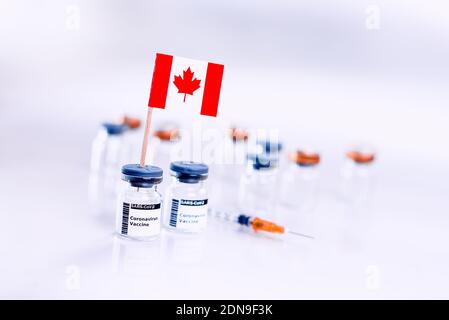 Coronavirus (COVID-19) vaccine vials with the flag of Canada. Stock Photo