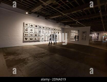 Un couple regardant des photographies dans une exposition à Salts Mill, Saltaire, Yorkshire, Angleterre. Banque D'Images