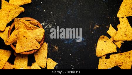 Saladier en bois Nachos IIN au maïs mexicain salé, fond noir, vue du dessus Banque D'Images