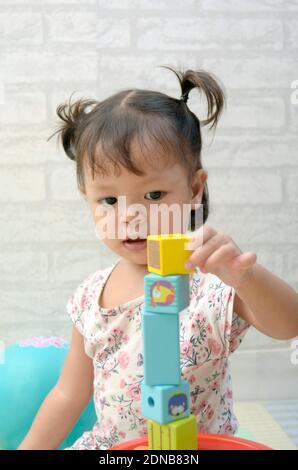Petite fille, 2 ans, jouant de bloc de bois coloré Banque D'Images