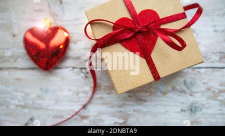 boîte cadeau avec coeur rouge sur fond de bois, saint valentin Banque D'Images