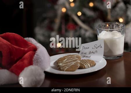 Note pour Santa assiette de biscuits et verre de lait traditionnel fond de Noël avec arbre de Noël. Faites le point sur la lettre de Noël pour le Père Noël. Banque D'Images