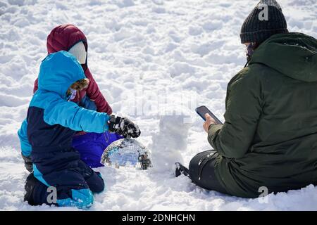 Les enfants jouent avec la neige dans le parc Washington Square pendant une tempête d'hiver.le matin, après une violente tempête d'hiver qui a frappé les États du nord-est des États-Unis, une tempête de neige majeure a frappé la côte est des États-Unis pendant les premières heures de jeudi, créer des défis supplémentaires au milieu d'une pandémie de coronavirus et d'un déploiement de vaccination de masse dans toute la région. La tempête d'hiver, qui s'est abattue sur New York, la Pennsylvanie et d'autres États du nord-est, laisse des millions de personnes faire face à plus d'un pied de neige par semaine avant Noël, ce qui pourrait perturber les tests de détection du coronavirus et retarder les livraisons pendant les fêtes. Il a également laissé plus de tha Banque D'Images